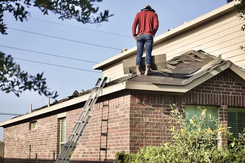 Professional roofer working on a residential roof in Boylston